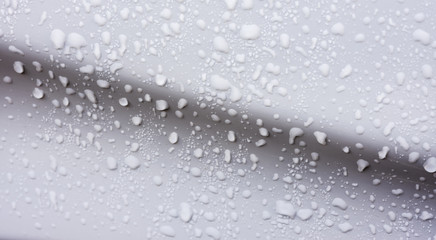 rain droplets on surface of white car body after shower