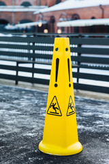 Slippery icon on yellow plastic alerts about hazard on road. Caution wet warning sign. Danger on road. Be aware on your way. Safety and attention concept