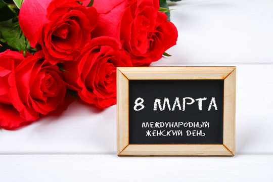Text in Russian: March 8. Black chalkboard and roses. International Women's Day.