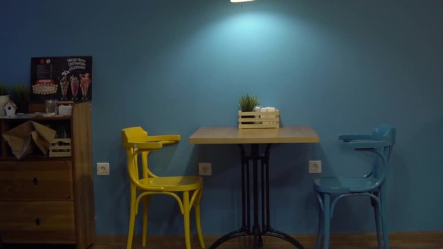 yellow and blue chair against a blue wall café