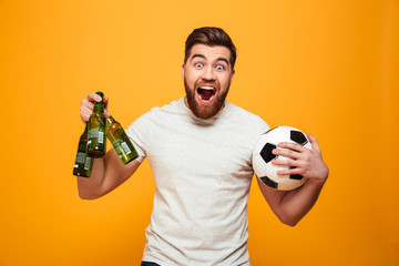 Portrait of a satisfied bearded man holding soccer ball