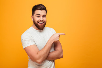 Portrait of a cheerful bearded man pointing finger