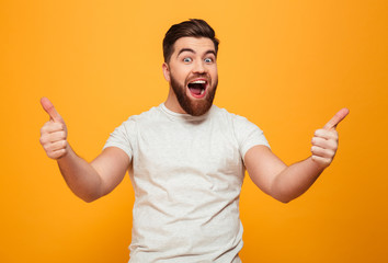 Portrait of a happy bearded man showing thumbs up - obrazy, fototapety, plakaty