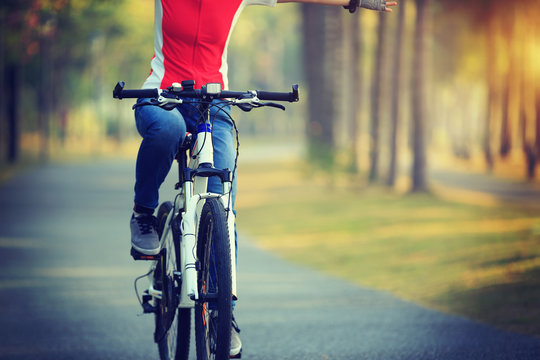 woman cyclist riding bike in tropical park