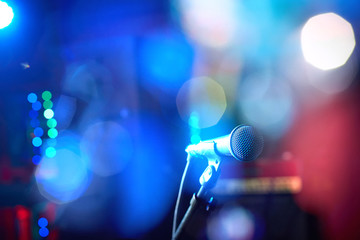 Obraz premium Closeup of a microphone for performance against a beautiful colored bokeh.