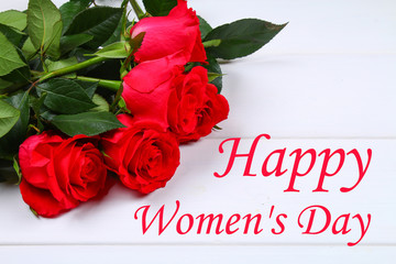 Happy woman's day. March 8. Roses on a white wooden table.