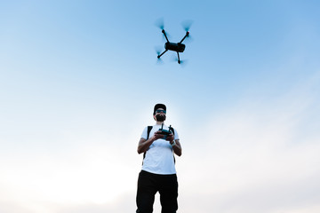 Man flying a drone copter by operating it © 4Max