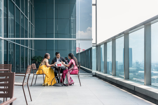 Three Indian Business People With Worried Facial Expression Talking During Break At Work