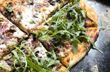 Pizza with salami, mozzarella and arugula