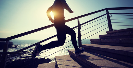 sporty female runner running upstairs on coast trail © lzf