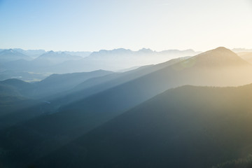 Panoramic view from Herzogstand with the mountainscape with foggy sunset.