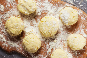 Making of russian style breakfast syrniki or cottage cheese pancakes on wooden table.