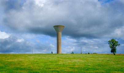 Water tower in the Mayenne countryside on an overcast day in summer, France