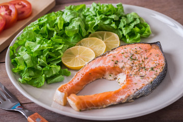 Grilled salmon steak covered with herb on plate