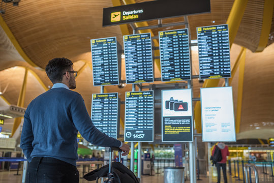 Man Checking His Flight On The Timetable Display At The Airport