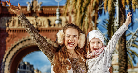 Obraz na płótnie Canvas happy modern mother and child in Barcelona, Spain rejoicing