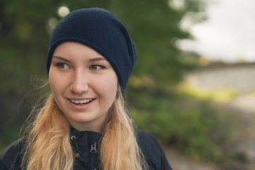 closeup portrait of smiling teen girl walking in a city on autumn day