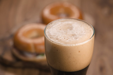 glass of stout beer agains bagels with ham