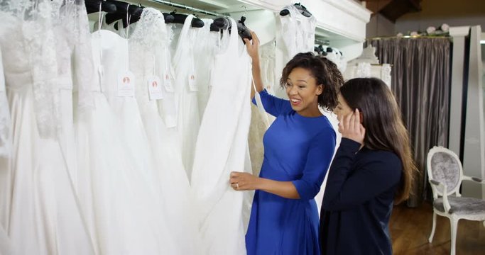 4k, Two young women shopping for a wedding dress at bridal store.