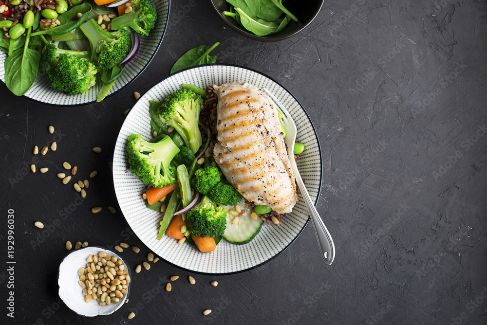 Wall mural grilled chicken breast, red rice and fresh broccoli vegetables, carrots, soybeans, spinach for garni