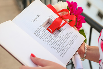 ring in a book with an engagement in hands