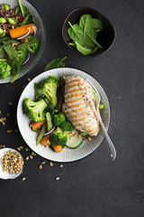 Grilled chicken breast, red rice and fresh broccoli vegetables, carrots, soybeans, spinach for garnish. With pine nuts. Top View.