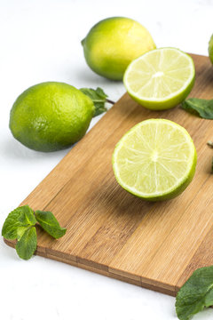 lime and mint on a wooden board closeup.