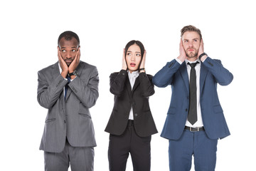 portrait of multicultural young business people covering ears isolated on white
