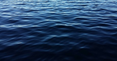 Dark blue water surface with ripples as a background 