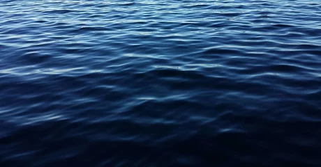 Schilderijen op glas Dark blue water surface with ripples as a background  © natalya2015