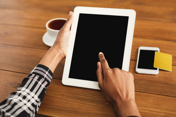 Black woman pointing with finger on digital tablet