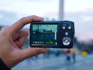 In man's hand a camera, on which is visible the Heroes Square in Budapest, Hungary.