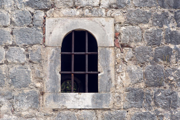 Fototapeta na wymiar window with grate in old building in Montenegro