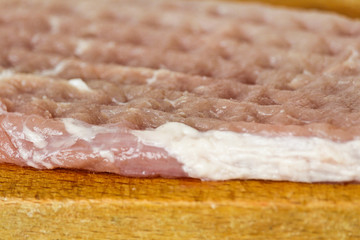 Fresh pork meat with structure on wood board from side