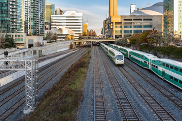 Passenger Trains on Parallel Tracks near a Station in Downtown Toronto on a Winter Day