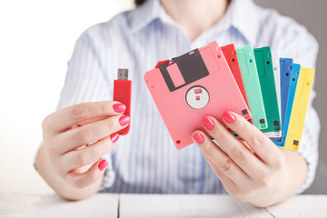 Female hold old floppy disk and modern flash drive