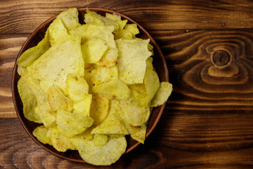 Plate of potato chips on wooden table