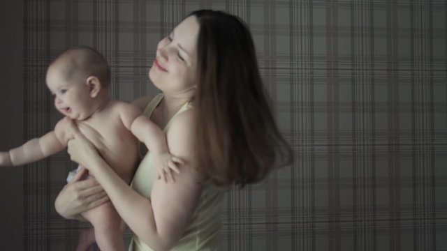 a mother with a small child in her arms against the wall
