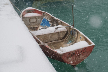 Abandoned snow covered red empty boat