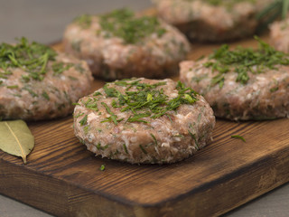 medallions of minced pork on a wooden board. 
