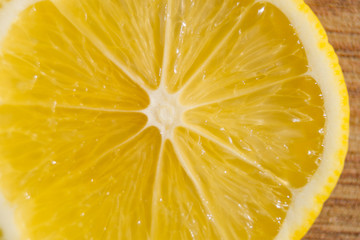 Slice of lemon on a wooden table.