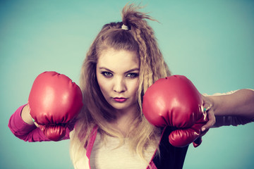 Cute girl in red gloves playing sports boxing