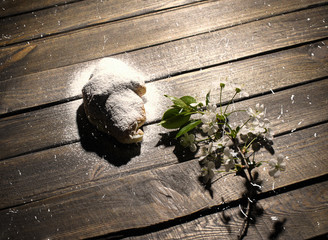 croissant on wooden desk with falling powdered sugar