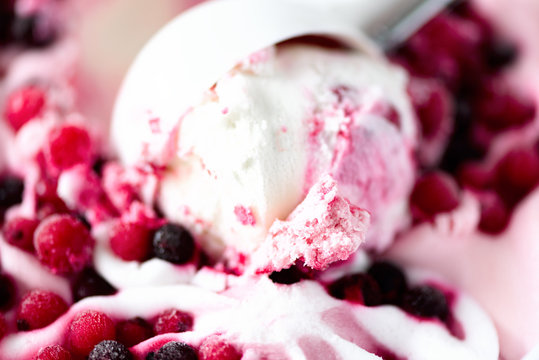 Scoop of pink ice cream with frosen berries. Summer food concept, copy space, top view. Sweet yogurt dessert or berries ice-cream background.