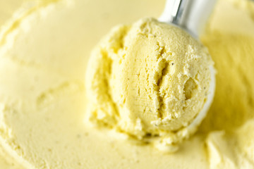 Vanilla ice cream scoop background. Summer food concept, copy space, top view. Scooped texture. Scooping out yellow ice-cream.