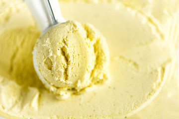Vanilla ice cream scoop background. Summer food concept, copy space, top view. Scooped texture. Scooping out yellow ice-cream.