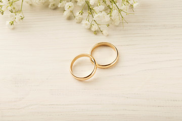 Two golden wedding rings with flower decorations