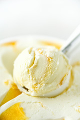 Vanilla ice cream scoop background. Summer food concept, copy space, top view. Scooped texture. Scooping out yellow mango ice-cream.