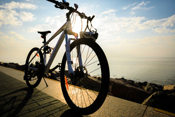 Fototapeta na wymiar mountain bike with helmet on sunrise seaside