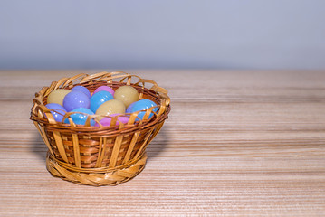 Easter eggs in a basket on a wooden background